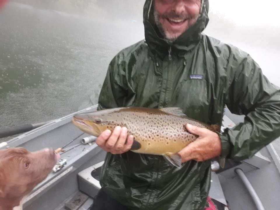 Large trout held aboard a fishing boat